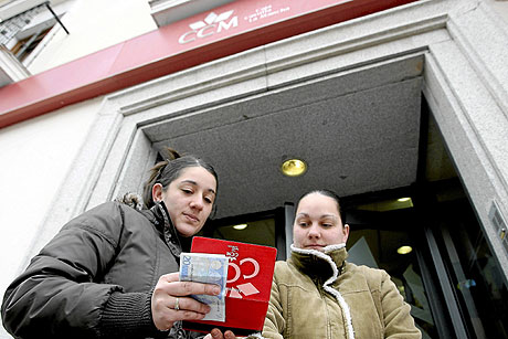 Una clienta de la caja saca dinero de una sucursal de Illescas (Toledo). | José Aymá