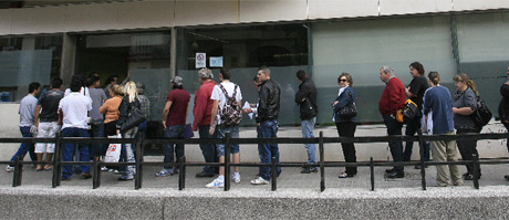 Varias personas esperan para entrar en una oficina del paro en Valencia. | José Cuéllar