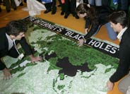 Participantes en la cumbre despliegan el mapa de Reporteros Sin Fronteras en el centro de convenciones (Foto: AP)