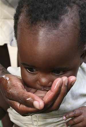 Un bebé toma agua de la mano de su madre en Harare. (Foto: AP)