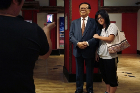 Una mujer se fotografía junto a una figura de cera del ex presidente chino Jiang Zemin. | Reuters